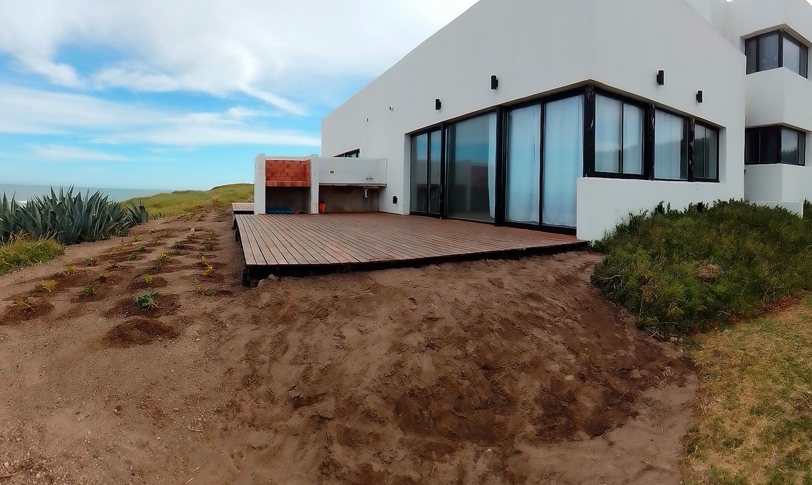 Construcción de deck de madera con canteros recién plantados junto al balneario