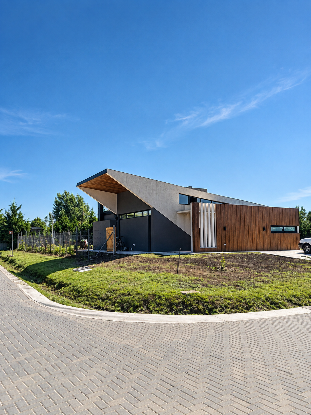 Vivienda de arquitectura moderna con césped y canteros recién implantados